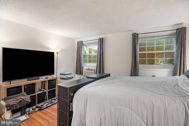 250 Ridge Pike Unit 58, Lafayette Hill, PA 19444 - bedroom featuring wood finished floors, a textured ceiling, multiple windows, and cooling unit