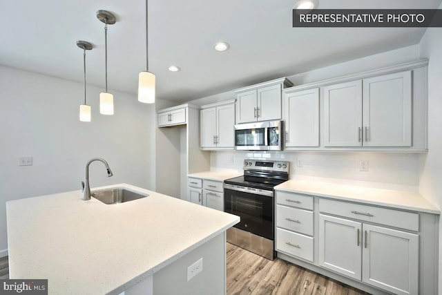 6329 Liam Dr Lot 54, Spring Grove, PA 17362 - kitchen featuring appliances with stainless steel finishes, light countertops, light wood-style flooring, hanging light fixtures, and recessed lighting