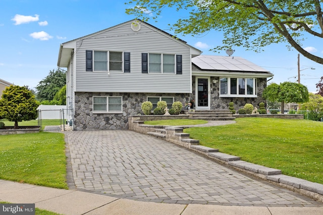 25 Toby Ln, Hamilton, NJ 08620 - tri-level home with stone siding, roof mounted solar panels, a gate, and decorative driveway