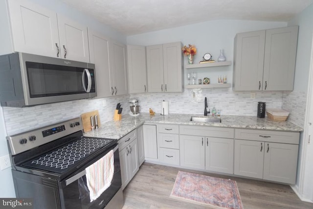 213 Conover St, Burlington, NJ 08016 - kitchen with appliances with stainless steel finishes, light wood-style floors, light stone counters, decorative backsplash, and lofted ceiling