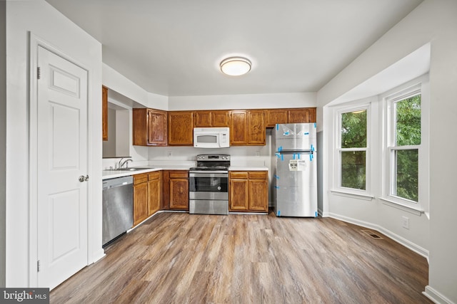 34 Ingate Ter Unit 4410, Halethorpe, MD 21227 - kitchen featuring stainless steel appliances, light countertops, light wood finished floors, and brown cabinets