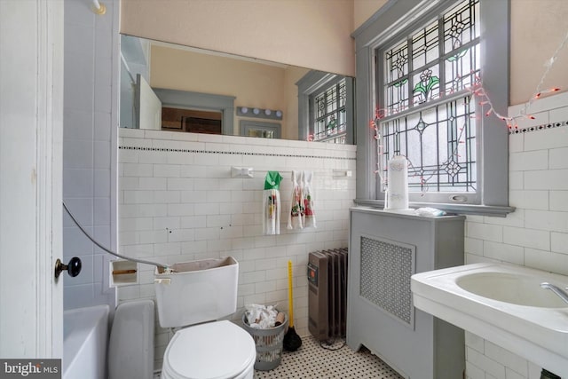 100 Springdale Rd, York, PA 17403 - bathroom with tile walls, radiator heating unit, and a tub to relax in