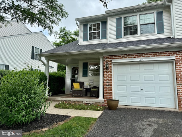 1009 Red Rock Cir, Royersford, PA 19468 - view of front of property with a porch, brick siding, roof with shingles, and driveway