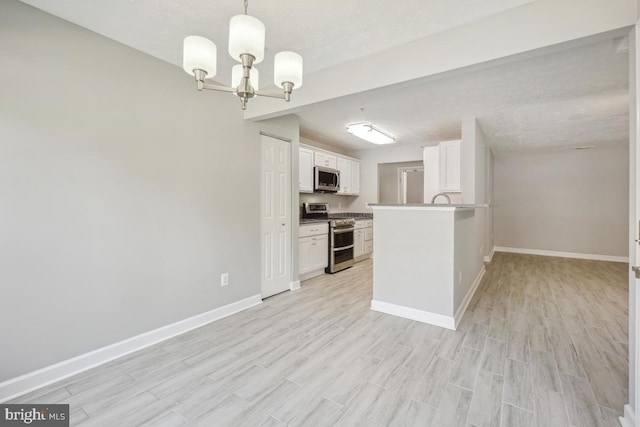 25909 Ridge Manor Dr Unit A, Damascus, MD 20872 - kitchen featuring stainless steel appliances, a chandelier, lofted ceiling, light wood finished floors, and white cabinets