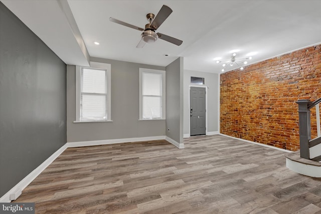405 N Loudon Ave, Baltimore, MD 21229 - unfurnished living room featuring brick wall, ceiling fan, and wood finished floors
