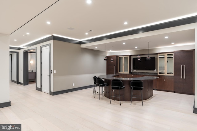 1020 Langley Hill Dr, Mclean, VA 22101 - kitchen with a breakfast bar area, a large island, glass insert cabinets, dark brown cabinets, and recessed lighting