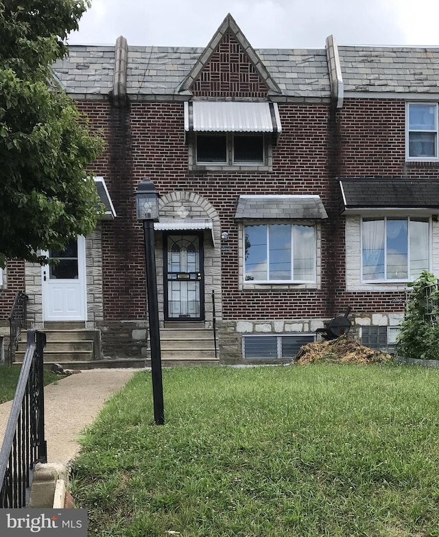 2206 Princeton Ave, Philadelphia, PA 19149 - view of front of home featuring a front yard, brick siding, entry steps, and a high end roof