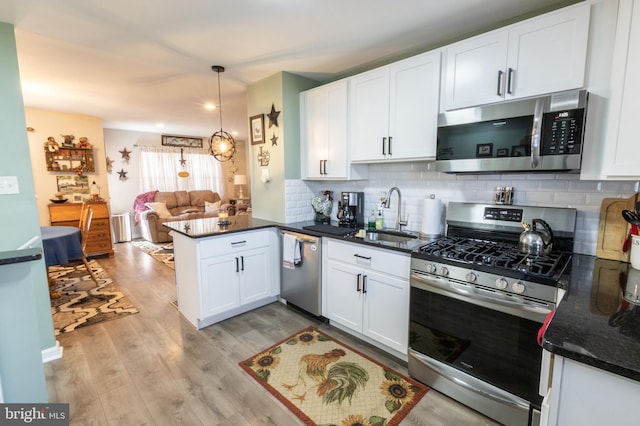 3 Cawdor Ln, New Castle, DE 19720 - kitchen with appliances with stainless steel finishes, a peninsula, white cabinets, open floor plan, and tasteful backsplash