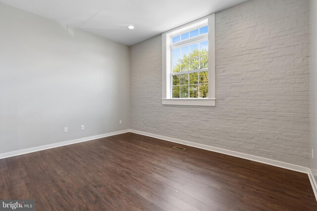 413 Jefferson St Unit 3, East Greenville, PA 18041 - spare room with brick wall and dark wood-type flooring