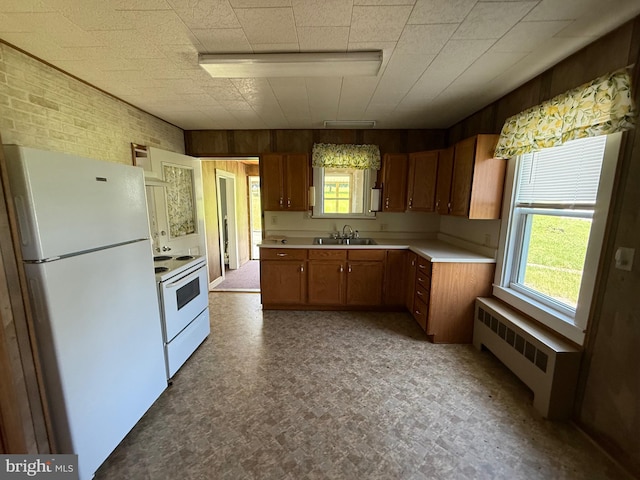 11 Gray Ridge Ln, Berkeley Springs, WV 25411 - kitchen with white appliances, radiator, light countertops, plenty of natural light, and brick wall