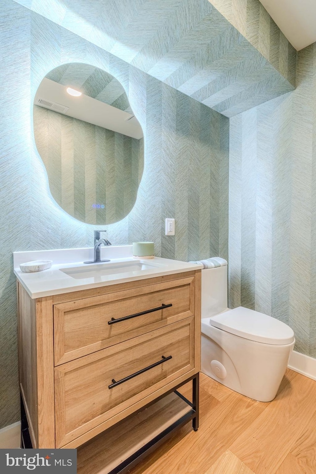5303 Rolling Rd, Springfield, VA 22151 - half bath featuring wood finished floors, vanity, and wallpapered walls