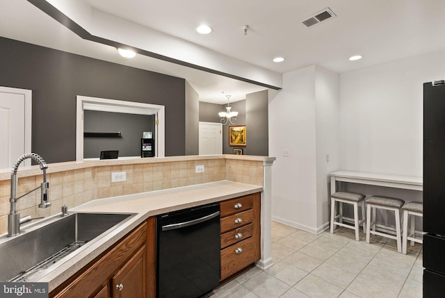 9710 Handerson Pl Unit 1, Manassas Park, VA 20111 - kitchen with black appliances, brown cabinets, backsplash, light tile patterned floors, and a chandelier