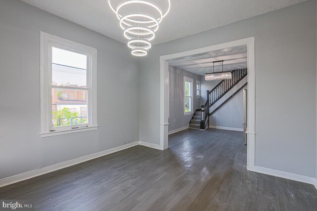 604 E 31st St, Baltimore, MD 21218 - spare room with dark wood finished floors, a chandelier, and stairway