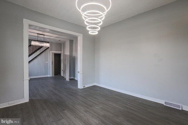604 E 31st St, Baltimore, MD 21218 - empty room with dark wood-type flooring and a chandelier