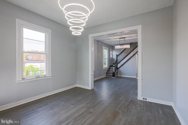604 E 31st St, Baltimore, MD 21218 - empty room with dark wood-style flooring, a chandelier, and stairs