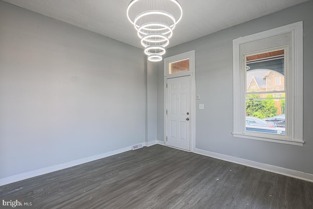 604 E 31st St, Baltimore, MD 21218 - unfurnished dining area with a chandelier and dark wood-style flooring