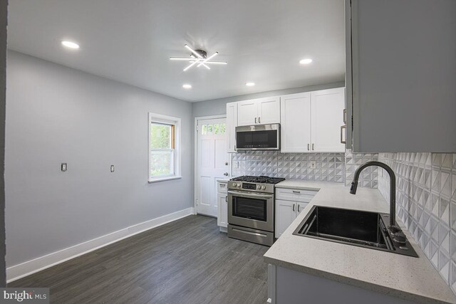 604 E 31st St, Baltimore, MD 21218 - kitchen featuring stainless steel appliances, decorative backsplash, dark wood-style floors, white cabinets, and recessed lighting