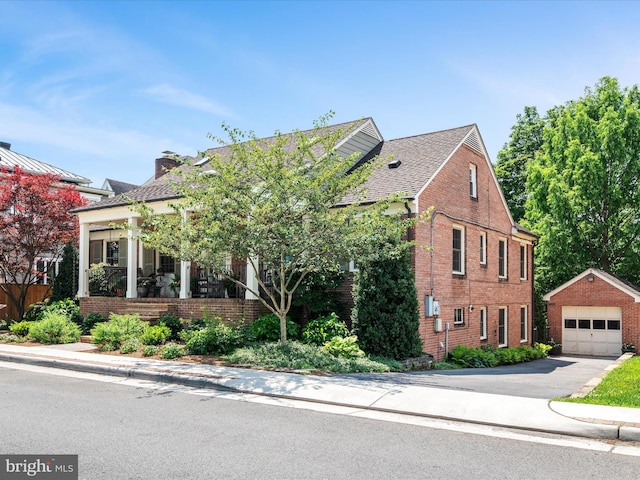 101 Morgan St, Winchester, VA 22601 - view of front facade featuring brick siding, an outdoor structure, a detached garage, and driveway