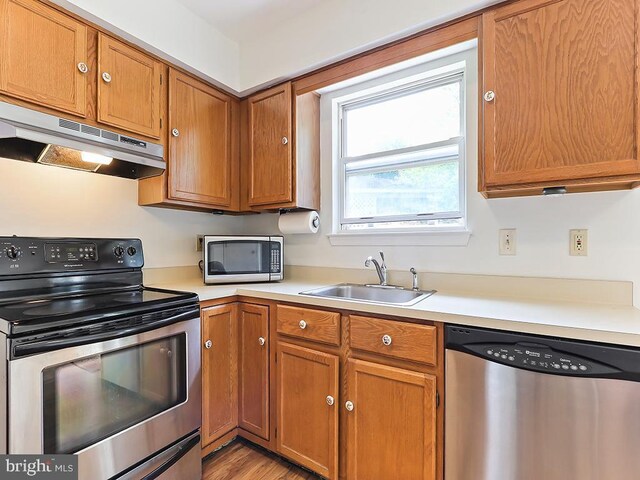 1035 Deerfield Cir, Perkasie, PA 18944 - kitchen with appliances with stainless steel finishes, under cabinet range hood, light countertops, and brown cabinetry