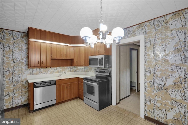 116 Chestnut St, Reading, PA 19607 - kitchen featuring appliances with stainless steel finishes, a chandelier, light countertops, wallpapered walls, and decorative light fixtures