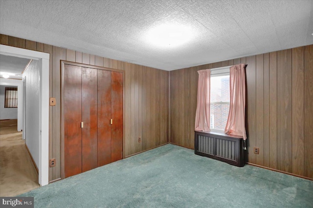 116 Chestnut St, Reading, PA 19607 - unfurnished bedroom featuring carpet floors, wooden walls, a closet, and a textured ceiling