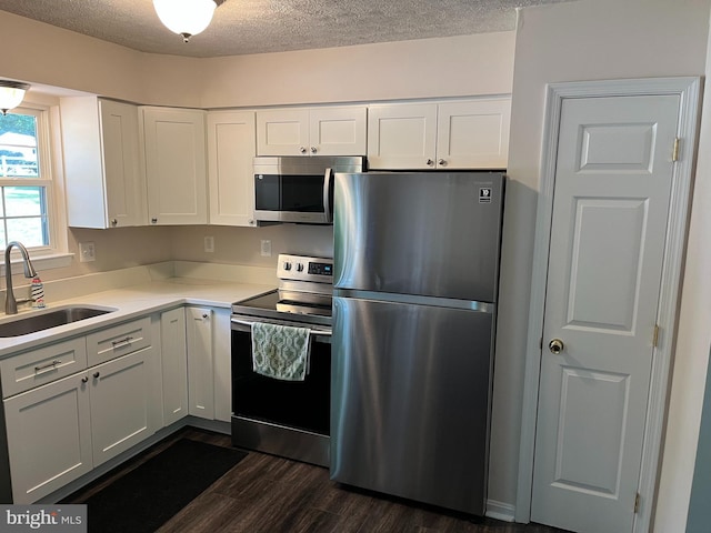 35904 Army Navy Dr, Mechanicsville, MD 20659 - kitchen featuring appliances with stainless steel finishes, dark wood-style flooring, white cabinets, light countertops, and a textured ceiling