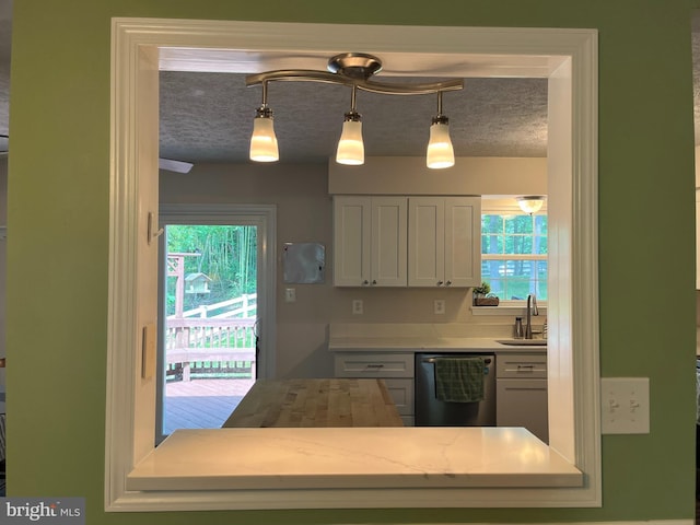 35904 Army Navy Dr, Mechanicsville, MD 20659 - kitchen with stainless steel dishwasher, light countertops, pendant lighting, and white cabinetry
