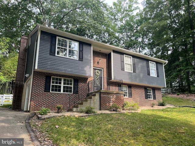 35904 Army Navy Dr, Mechanicsville, MD 20659 - view of front facade featuring brick siding, a front yard, a chimney, and asphalt driveway