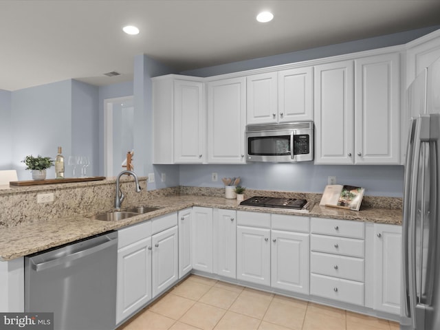 1473 Northern Neck Dr, Vienna, VA 22182 - kitchen with stainless steel appliances, white cabinets, light stone countertops, recessed lighting, and light tile patterned floors