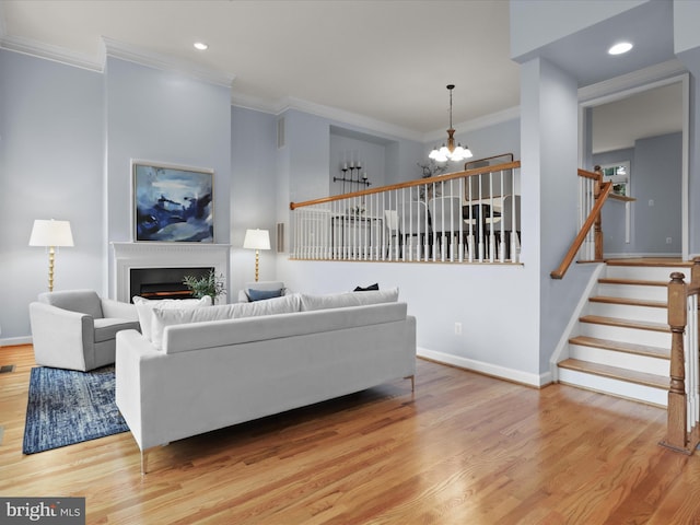 1473 Northern Neck Dr, Vienna, VA 22182 - living room with a chandelier, ornamental molding, wood finished floors, a warm lit fireplace, and stairway