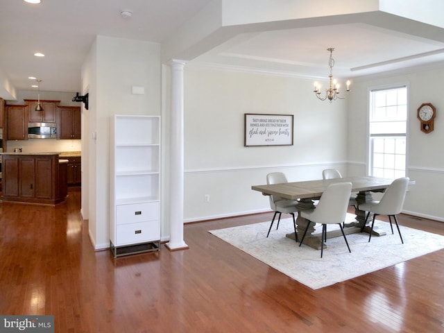 15152 Santander Dr, Gainesville, VA 20155 - dining area featuring dark wood-style flooring, a chandelier, recessed lighting, decorative columns, and a raised ceiling