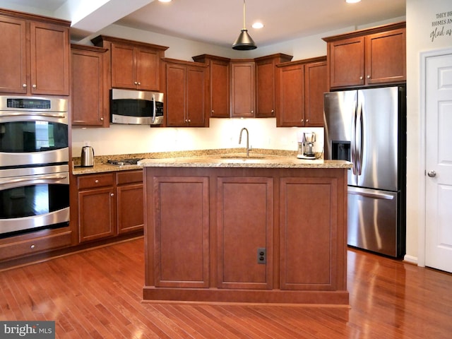 15152 Santander Dr, Gainesville, VA 20155 - kitchen with appliances with stainless steel finishes, recessed lighting, wood finished floors, light stone countertops, and hanging light fixtures