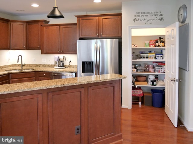 15152 Santander Dr, Gainesville, VA 20155 - kitchen with appliances with stainless steel finishes, wood finished floors, brown cabinetry, light stone countertops, and recessed lighting
