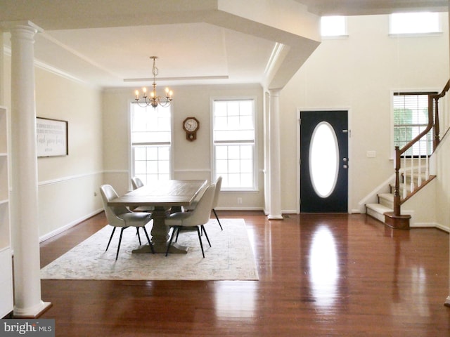 15152 Santander Dr, Gainesville, VA 20155 - dining room featuring wood finished floors, a tray ceiling, a chandelier, stairs, and ornate columns