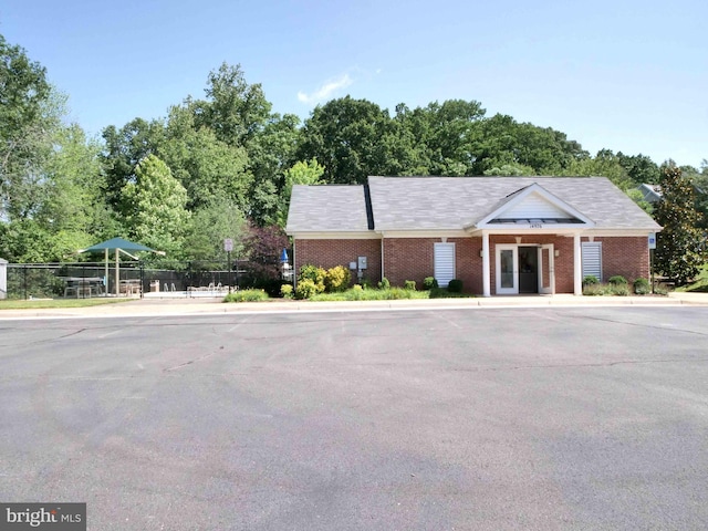 15152 Santander Dr, Gainesville, VA 20155 - view of front of house with brick siding, view of wooded area, and uncovered parking