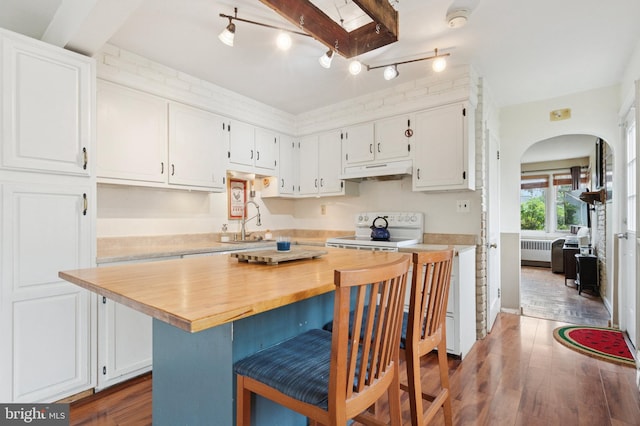 589 Wilson St, Pottstown, PA 19464 - kitchen with white electric range, under cabinet range hood, radiator, arched walkways, and white cabinets