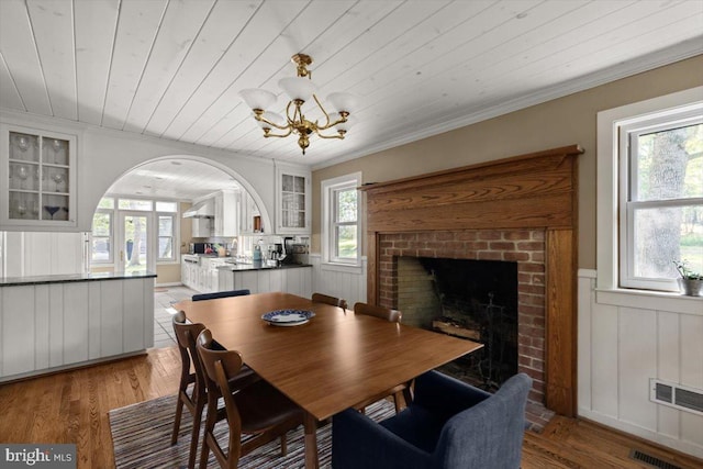 200 Sweetbriar, Winchester, VA 22603 - dining area with arched walkways, a chandelier, wooden ceiling, wainscoting, and a brick fireplace