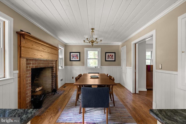 200 Sweetbriar, Winchester, VA 22603 - dining space featuring wainscoting, a chandelier, crown molding, wood finished floors, and a brick fireplace