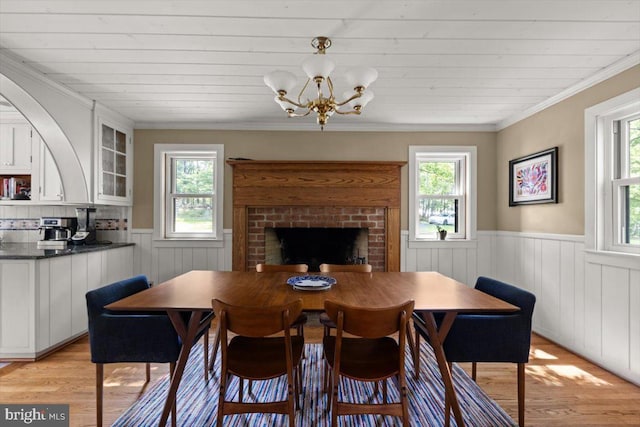 200 Sweetbriar, Winchester, VA 22603 - dining room with a wainscoted wall, light wood finished floors, a brick fireplace, a chandelier, and ornamental molding
