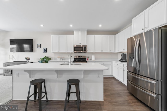 346 Goodwick Dr, Middletown, DE 19709 - kitchen featuring stainless steel appliances, white cabinetry, a center island with sink, a kitchen bar, and light countertops