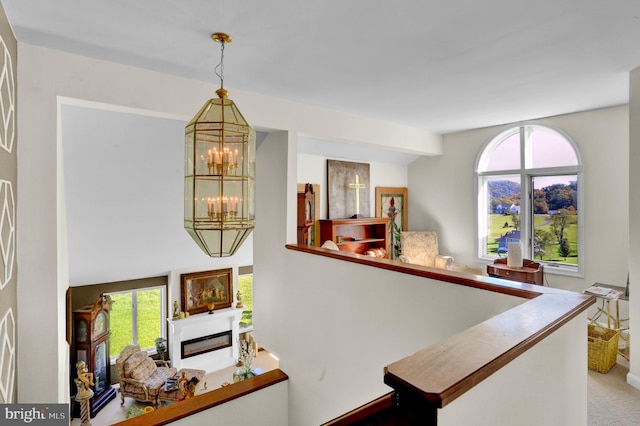 1319 Shady Ln, Tamaqua, PA 18252 - stairway featuring a chandelier, plenty of natural light, a glass covered fireplace, and carpet floors