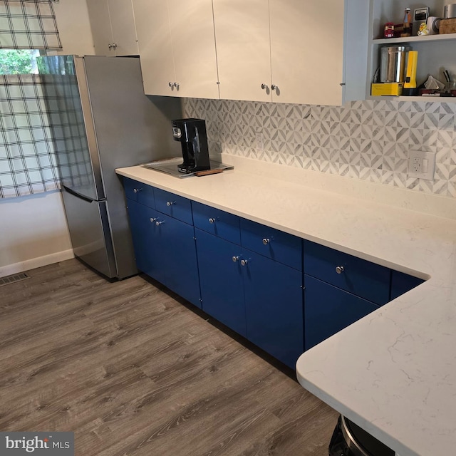 12987 Holly Way, Lusby, MD 20657 - kitchen with blue cabinetry, dark wood-style floors, light countertops, and tasteful backsplash