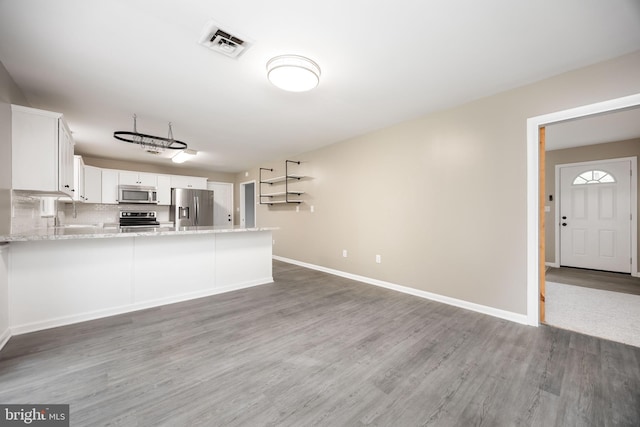 7043 Cromwell Ave, Salisbury, MD 21804 - kitchen with stainless steel appliances, light wood finished floors, white cabinets, a peninsula, and backsplash