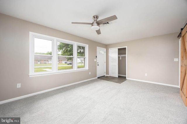 7043 Cromwell Ave, Salisbury, MD 21804 - unfurnished bedroom featuring a barn door, carpet, a closet, and a ceiling fan