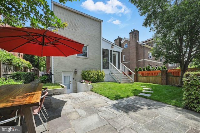 1646 Foxhall Rd NW, Washington, DC 20007 - rear view of house featuring a sunroom, brick siding, and a patio