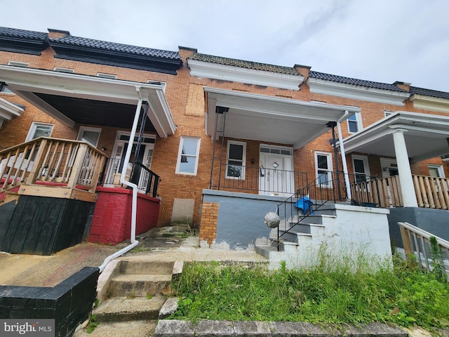 3507 W Garrison Ave, Baltimore, MD 21215 - view of front of house featuring covered porch, brick siding, stairway, and a tiled roof