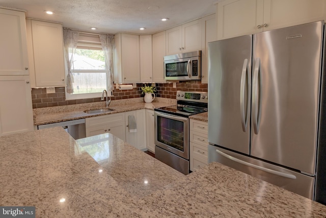 4328 Rolling Stone Way, Alexandria, VA 22306 - kitchen featuring appliances with stainless steel finishes, light stone counters, white cabinetry, and backsplash