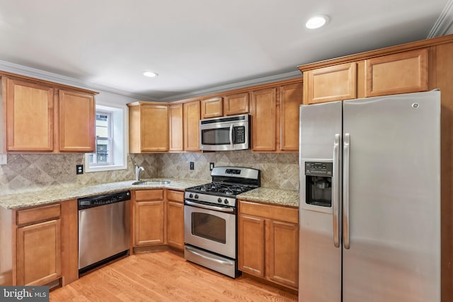 434 N Budd St, Philadelphia, PA 19104 - kitchen with stainless steel appliances, light wood-style floors, tasteful backsplash, light stone countertops, and ornamental molding