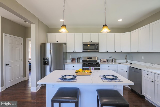 4001 Ridgecroft Rd, Baltimore, MD 21206 - kitchen featuring appliances with stainless steel finishes, a kitchen bar, white cabinets, dark wood-style floors, and recessed lighting