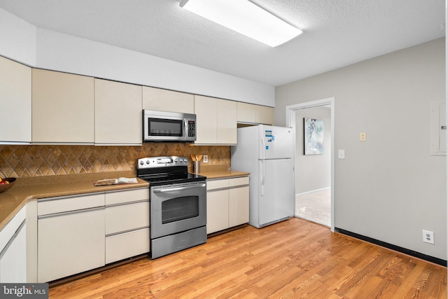5501 Seminary Rd Unit 407S, Falls Church, VA 22041 - kitchen with appliances with stainless steel finishes, backsplash, light wood-style flooring, light countertops, and white cabinetry